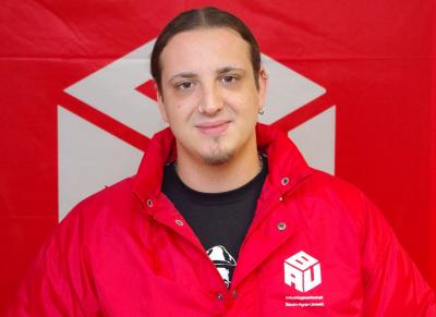 Harry Gosch in roter BAU-Jacke vor einer roten BAU-Fahne Harry Gosch in roter BAU-Jacke vor einer roten BAU-Fahne
